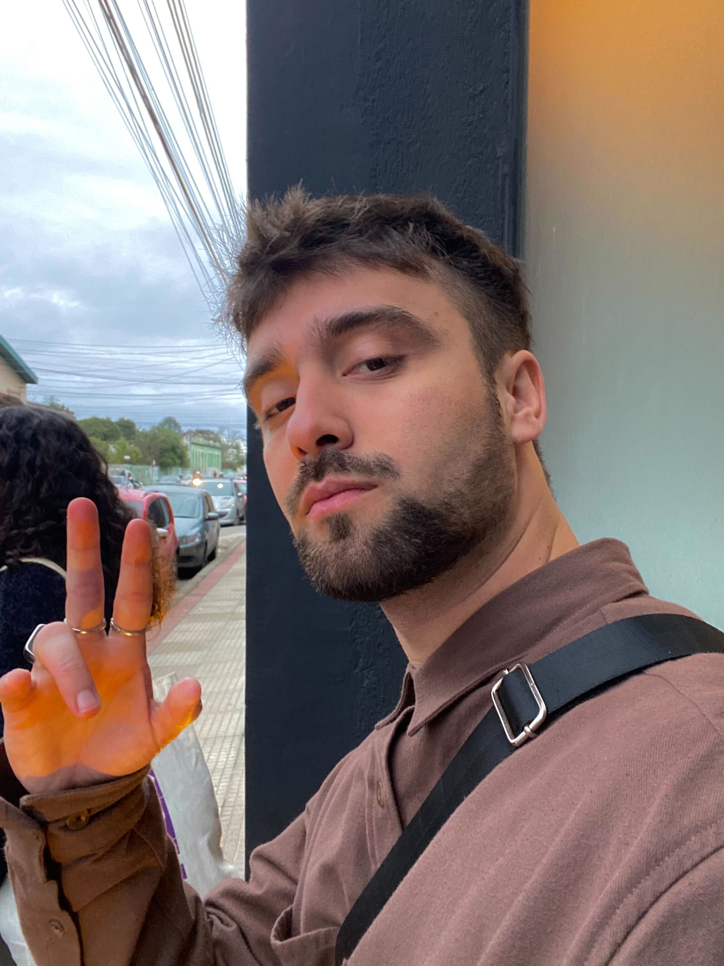 Portrait of a man with brown hair and glasses on a flat gray background.
